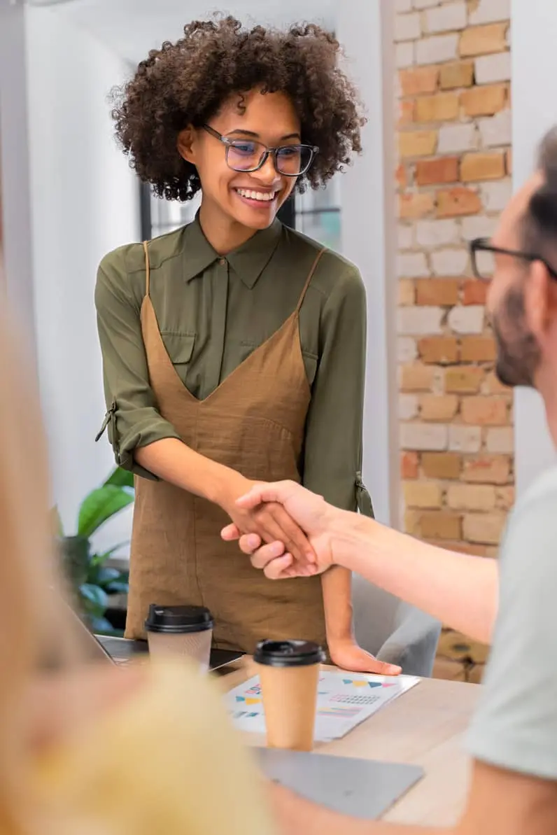 femme d'affaire qui serre la main à un collaborateur